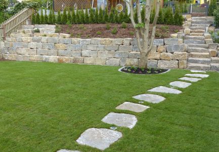 Steinmauer mit Garten und steinernem Gartenweg