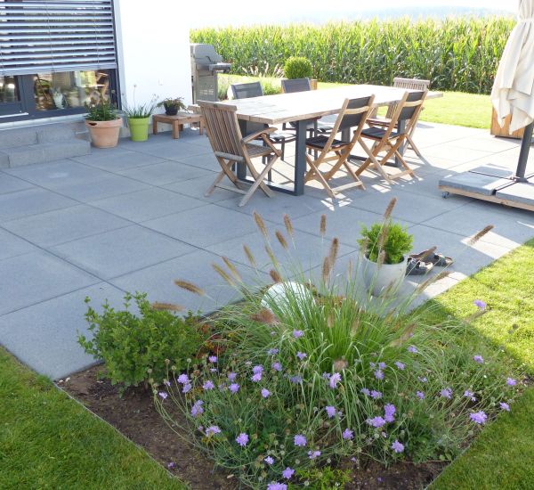 Gartenmauer aus Pflastersteinen und Metall als Sichtschutz