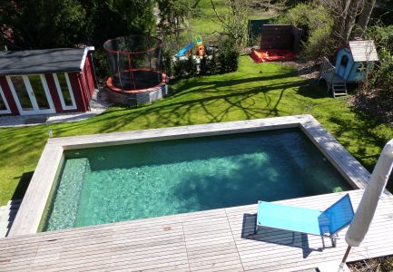 Schwimmerin geniest den Naturpool in der Sonne