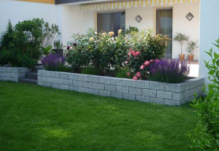 Kleine Steinmauer mit Blumenbeet
