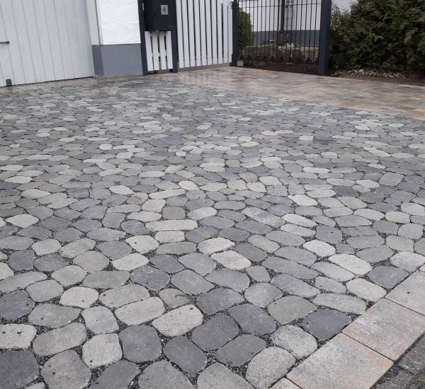 Gartenmauer aus Pflastersteinen und Metall als Sichtschutz